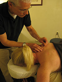 Fine acupuncture needles placed along the skin during a treatment.