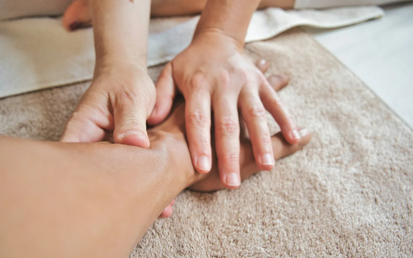 A reflexologist applying pressure to points on the foot