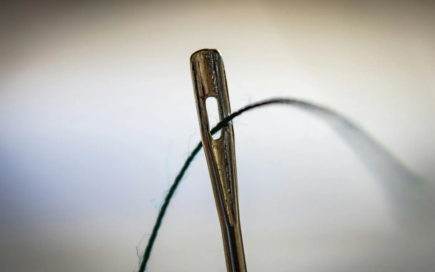 Close view of a single sterile acupuncture needle, finer than a sewing needle